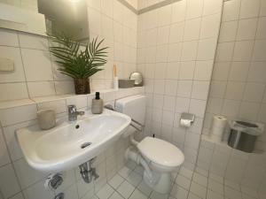 Baño blanco con aseo y lavamanos en Charming Apartment - Balcony - Netflix - Kitchen, en Magdeburgo