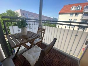 a table and chairs on a balcony with a fence at Charming Apartment - Balcony - Netflix - Kitchen in Magdeburg