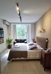 a bedroom with a large bed and a window at Baixo Copa Guest House in Rio de Janeiro
