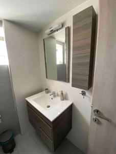 bagno con lavandino e specchio di LUXURY APARTMENTS 1 VOLOS a Volos