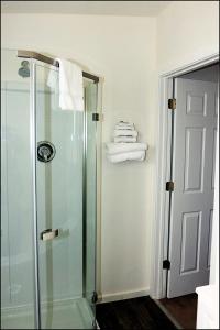 y baño con cabina de ducha de cristal y toallas. en Antler Motel en Kemmerer