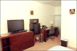 a room with a television and a desk with a computer at Antler Motel in Kemmerer