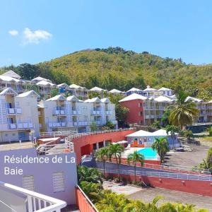 a view of a resort with a mountain in the background at Les Studios de la Baie 246 in La Trinité