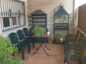 d'une terrasse avec des chaises, une table et un piano. dans l'établissement Alojamiento Los Poetas, à Baeza