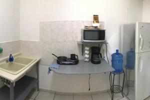 a kitchen with a table with a microwave and a sink at Cerca del IMSS Depa OtancahuiBerna (Facturable) in Ciudad Obregón