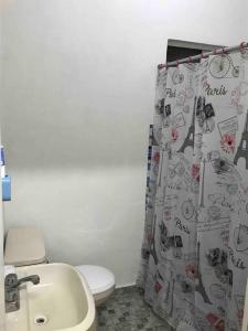 a bathroom with a toilet and a sink and a shower curtain at Cerca del IMSS Depa OtancahuiBerna (Facturable) in Ciudad Obregón