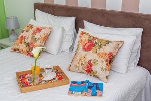 ein Bett mit zwei Kissen und ein Tablett mit einer Vase darauf in der Unterkunft Apartments Fortunella in Petrovac na Moru
