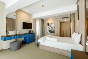 a hotel room with a large bed and a television at Onal Boutique Hotelier in Mamaia
