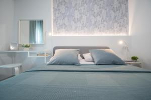 Schlafzimmer mit einem Bett mit blauer Decke in der Unterkunft Apartamento Sunset Cádiz in Cádiz