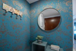 ein Badezimmer mit blauen Wänden und einem Spiegel in der Unterkunft Apartamento Sunset Cádiz in Cádiz