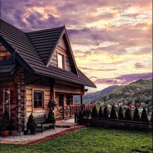 una casa de madera con un banco delante en Chata Natura, en Muszyna