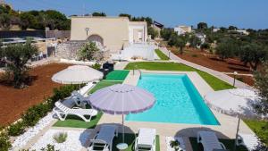 an overhead view of a swimming pool with umbrellas at Villa Stella in Marina di Pescoluse