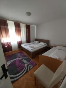 a room with two beds and a chair in it at Šadrvan Una Apartment in Bihać