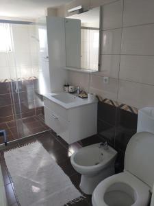 a bathroom with a white toilet and a sink at Šadrvan Una Apartment in Bihać +20 photos