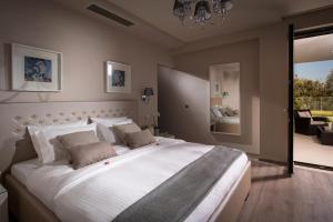 a bedroom with a large white bed with a large window at Villa Belamar in Hersonissos +24 photos