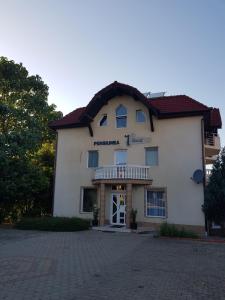 a large white building with a balcony on a driveway at Vila David in Baile Unu Mai
