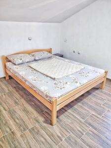 a large bed in a bedroom with a wooden floor at Apartments Iva in Star Dojran
