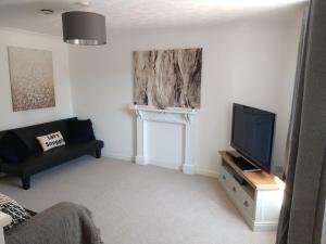 a living room with a television and a couch at Stamford Redcot Gardens Stylish 2 bed Family town house with parking in Lincolnshire