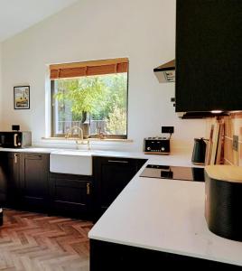 Balsham的住宿－Finest Retreats - Blackbarn Wood，厨房设有水槽和窗户。