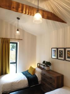 Balsham的住宿－Finest Retreats - Blackbarn Wood，一间卧室配有两张床、一个梳妆台和灯