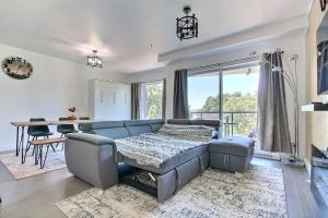 een woonkamer met een blauwe bank en een tafel bij GOOD VIBES ONLY -Modern and spacious 2 bedroom condo 4 beds FREE PARKING, GYM in Québec