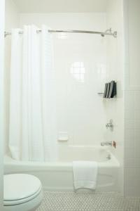 a white bathroom with a toilet and a bath tub at Herbert Hotel in San Francisco