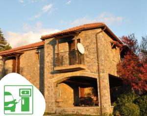 a large stone house with a balcony on the side at Kastraki Vacations House in Dimitsana