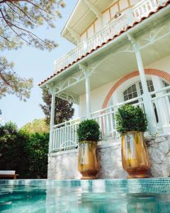 two potted plants sitting on the side of a house at Hôtel Hemen in Saint-Palais-sur-Mer