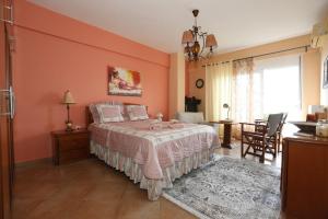 a bedroom with a bed with a pink wall at Sofia's pottery house in Volos