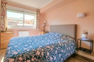 1 dormitorio con 1 cama con manta azul y ventana en La Douce Vie, en Le Touquet-Paris-Plage