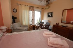 a bedroom with a large bed and a living room at Sofia's pottery house in Volos