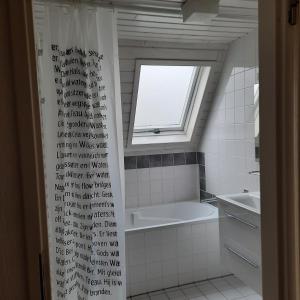 a bathroom with a window and a bath tub at De Gouwe, 158 - aan visvijver, de beste visstek in Gramsbergen