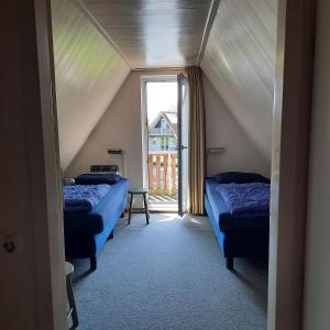two beds in a room with a window at De Gouwe, 158 - aan visvijver, de beste visstek in Gramsbergen