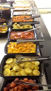 a row of trays filled with different types of food at Baruch Hotel in Araguaína