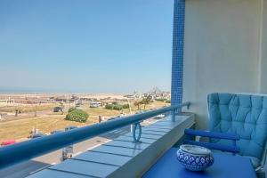 a balcony with a chair and a view of a beach at La Douce Vie in Le Touquet-Paris-Plage