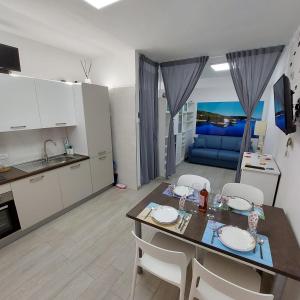 a kitchen and living room with a table and chairs at CASA VACANZE NANA' VIESTE in Vieste