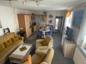 ein Wohnzimmer mit Sofa, Fernseher und Küche in der Unterkunft Himmlisch Wohnen in Bergen auf Rügen