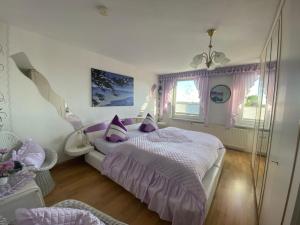 ein Schlafzimmer mit einem großen Bett und lila Kissen in der Unterkunft Himmlisch Wohnen in Bergen auf Rügen