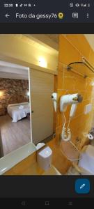 un bagno con specchio e una camera con un letto di Villa Raggio di Sole parcheggio privato a Porto Cesareo
