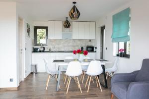 Flow House&Garden في باداتشونيتوماي: مطبخ وغرفة معيشة مع طاولة وكراسي
