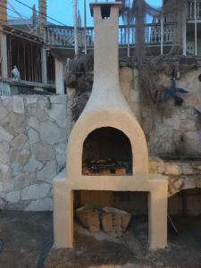 een pizza-oven in de openlucht naast een stenen muur bij IN Villa Guesthouse in Sutomore
