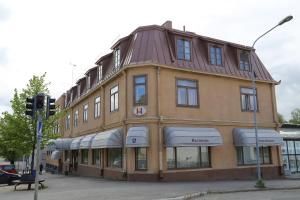 a building on the corner of a street with a traffic light at Hotelli Iisalmen Seurahuone in Iisalmi