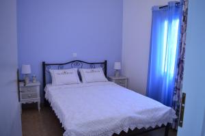 um quarto azul com uma cama com lençóis brancos e almofadas em La Casa Azul - Blue House - Το Μπλε Σπίτι em Sitia