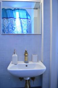 um lavatório branco na casa de banho com um espelho em La Casa Azul - Blue House - Το Μπλε Σπίτι em Sitia