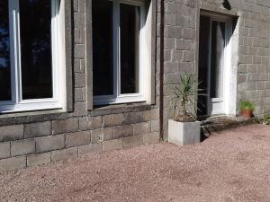 un edificio de ladrillo con dos ventanas y una maceta en Sous la charmille., en Cerisy-la-Salle