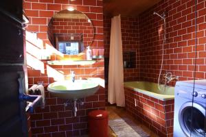 ein rotes Backsteinbad mit einem Waschbecken und einer Badewanne in der Unterkunft Casa Bruja Tradizionale Rustico Ticinese in Mergoscia