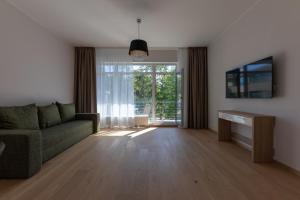 a living room with a couch and a large window at Oasis Apartments in Jūrmala