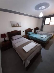 - une chambre avec deux lits et une lampe dans l'établissement Almarsa1, à Al Hoceïma
