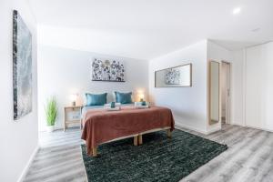 Dormitorio blanco con cama con almohadas azules en Frontline Seaview Apartment en Budens