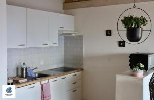 uma cozinha com armários brancos e um lavatório em Cà Armonia Luminoso apt con vista panoramica em Mergoscia
